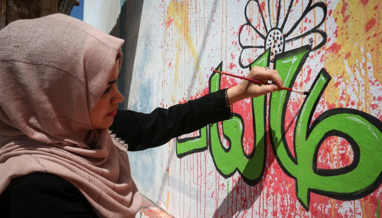 Photo by Abed Rahim Khatib/Flash90 אמנים פלסטינים מציירים ציור קיר תחת האמירה "לא לאלימות" במהלך המחאה על אלימות כלפי נשים "No to violence"